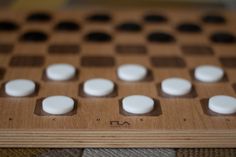 a wooden board game with white and black squares