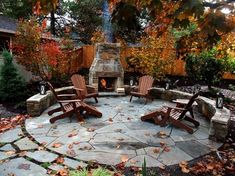 an outdoor fire pit surrounded by wooden chairs