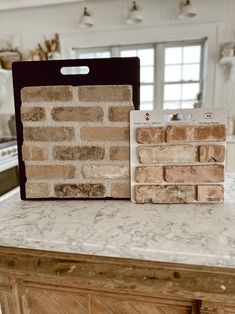 a kitchen counter with two bricks on top of it and one in front of the other