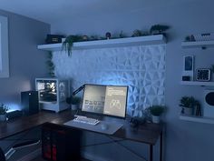 a computer desk with a monitor, keyboard and speakers on it in a home office