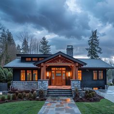 a house that is lit up at night with lights on the front door and steps leading to it