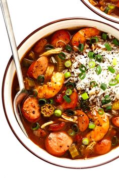 two bowls filled with different types of food and rice on top of each other,