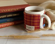 a coffee mug sitting on top of a table next to some books