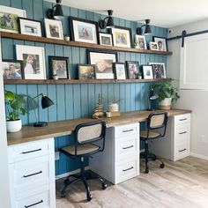 a desk with two chairs and pictures on the wall