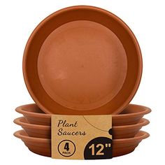 four brown plant saucers stacked on top of each other in front of a cardboard box