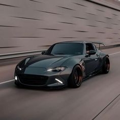 a gray sports car driving down the road