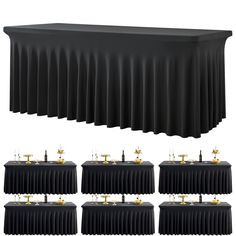 the table is lined with black cloths and gold candles