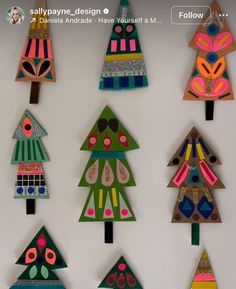 colorful paper christmas trees are hanging on the wall