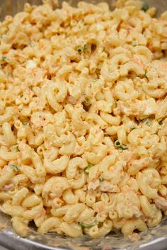 the macaroni and cheese is mixed together in a large metal bowl, ready to be eaten