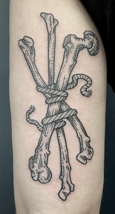 a black and white tattoo with bones tied to it