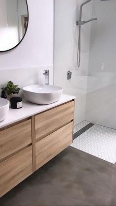 a bathroom with two bowls on the counter and a shower in the backround