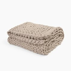 two blankets folded on top of each other in light beige colored knitted material, one with