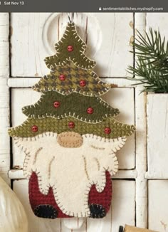 a christmas ornament hanging on the side of a white door with a pine tree