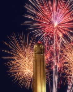 fireworks are lit up in the night sky above a tower with a clock on it