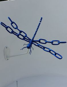 a blue dragon flys through the air with chains attached to it's wings