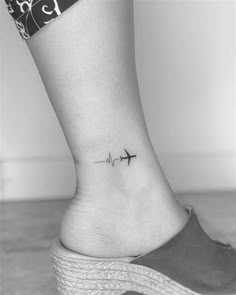 a woman's ankle with a small airplane tattoo on her left side ribcage