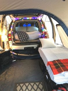 the interior of a camper van with two beds in it and lights all around