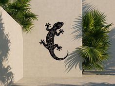 an image of a lizard that is on the side of a building with palm trees