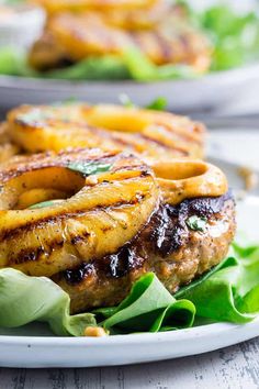 grilled pineapple burgers with lettuce and greens on a white plate