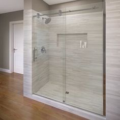 a bathroom with a glass shower door and wood flooring on the side of the room