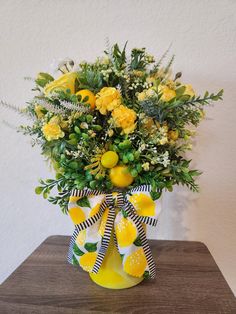 a vase filled with yellow flowers and greenery