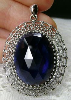 "Simulated Blue Sapphire Pendant Mesh Design#P14 Custom Made Inspired by Victorian era jewelry, I now offer this lovely Antique reproduction in sterling silver. The 20ct simulated blue sapphire gemstone is 24mm long (just shy of 1 inch) and 18mm in width (11/16th\"). The entire pendant is 1 3/4th inches long. The necklace/bail opening is 5mm x 3mm. Notice the beautiful craftsmanship of the Victorian filigree setting. The original antique piece that this pendant was designed from, was a Victorian Victorian Era Jewelry, Victorian Filigree, Blue Sapphire Pendant, Blue Sapphire Gemstone, Sapphire Pendant, Mystic Topaz, Antique Design, Mesh Design, Engraved Items