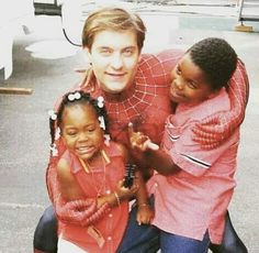 the spider man is posing with two children