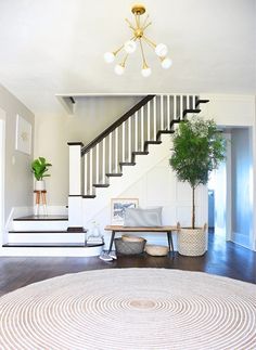 a living room with stairs and a rug on the floor