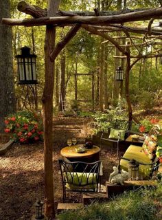 an outdoor seating area with chairs and tables in the woods