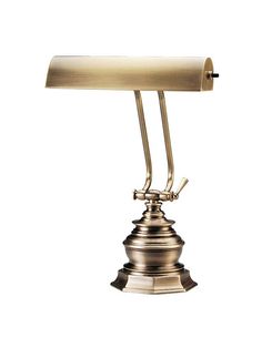 an antique brass desk lamp on a white background