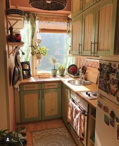 a small kitchen with green cabinets and wood flooring is pictured in this image from the doorway