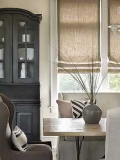 a dining room table with two chairs and a china cabinet