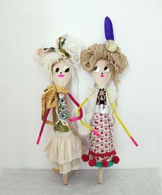 two dolls standing next to each other on top of a white wall with the words spoon puppets written above them