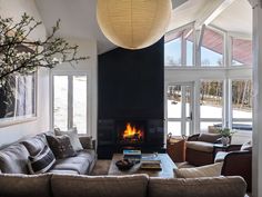 a living room filled with furniture and a fire place in the middle of it's wall