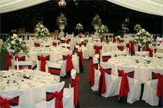 a banquet hall with tables and chairs covered in red, white and blue sashes