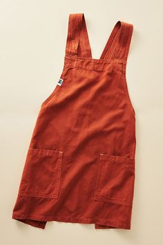 an orange overall style dress on a white surface