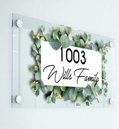 a glass plaque with the words 1003 willis family surrounded by green leaves and flowers