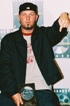 a man holding an award in his right hand and pointing to the side with both hands