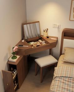 a bedroom with a bed, desk and chair next to a wall mounted mirror on the wall