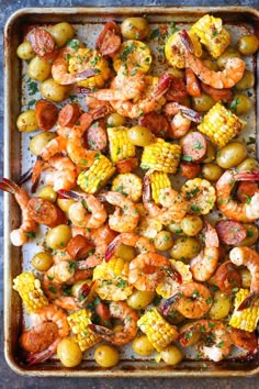 shrimp, corn and potatoes on a baking sheet