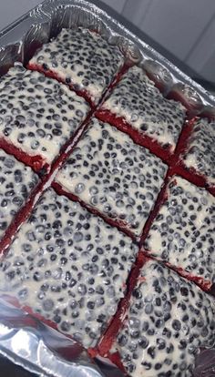 a pan filled with different types of desserts on top of tin foil covered in berries