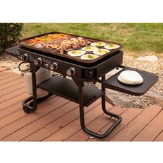 an outdoor bbq grill with food on the top and side burners, sitting on a patio