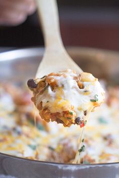 a spoon full of food is being lifted from a pan with the casserole