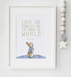 a white frame with a blue and yellow quote on it next to a bead necklace