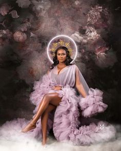 a woman sitting on top of a cloud filled floor wearing a purple dress and headpiece