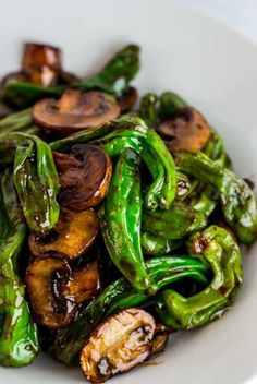 a white bowl filled with green peppers and mushrooms