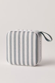 a white and gray striped case with a ribbon on the side that is attached to it