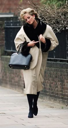 a woman walking down the street carrying a purse