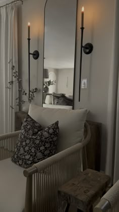 a living room with a couch, mirror and two candles on the wall next to it