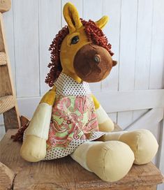 a stuffed giraffe sitting on top of a wooden chair